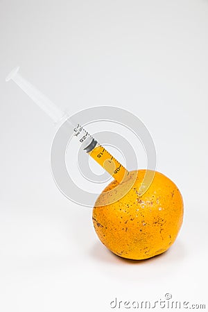 Real orange fruit was sucked by syringe Stock Photo