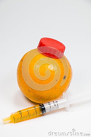 Real orange fruit was sucked by syringe Stock Photo