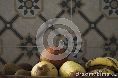 A real organic red apple with other fruits in a wooden tray over a vintage background. Stock Photo