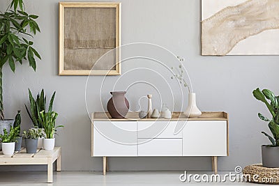 Real photo of a botanic living room interior with burlap artwork Stock Photo