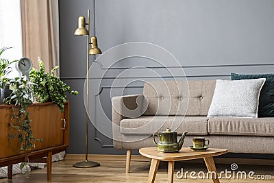 Real photo of a couch with pillows standing behind a small table Stock Photo