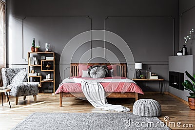 Real photo of a cozy bedroom interior with wooden bed in the mid Stock Photo