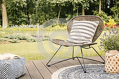 Real photo of a modern garden chair with a white, striped pillow Stock Photo