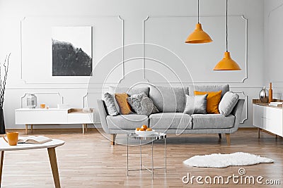 Photo of a modern living room interior with a sofa, orange lamps and painting Stock Photo