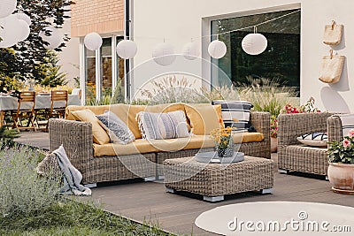 Real photo of a garden furniture set with lamps and table in the background Stock Photo