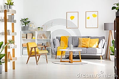 Real photo of a scandi living room interior with gray and yellow Stock Photo