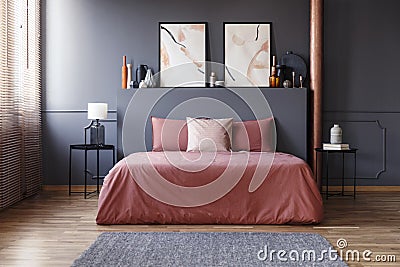 Real photo of a simple bedroom interior with dirty pink bedding Stock Photo