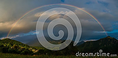 Real rainbow above a small village Stock Photo