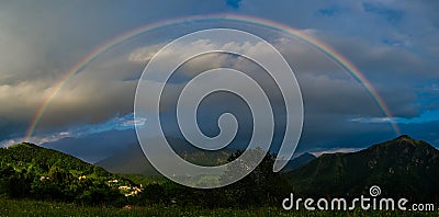 Real rainbow above a small village Stock Photo