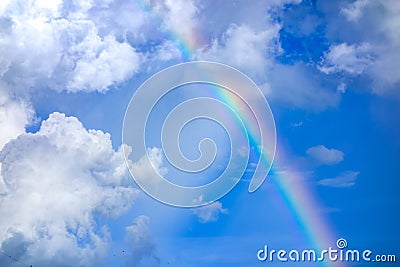 Real rainbow on blue sky with clouds nature background. Stock Photo