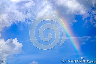 Real rainbow on blue sky with clouds nature background. Stock Photo