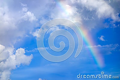 Real rainbow on blue sky with clouds nature background. Stock Photo