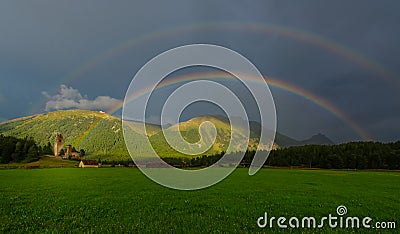 Real rainbow in a mountain meadow Stock Photo