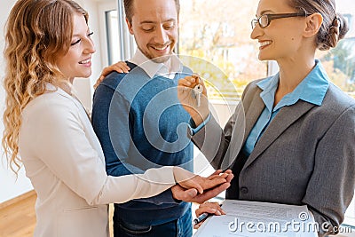 Realtor giving house key to the buyers or tenants Stock Photo