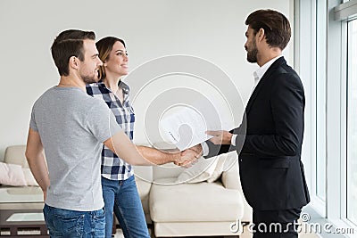 Realtor or landlord handshaking couple tenants make real estate deal Stock Photo