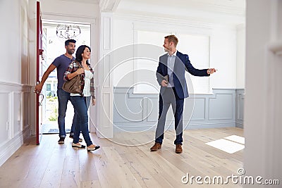 Realtor Showing Hispanic Couple Around New Home Stock Photo