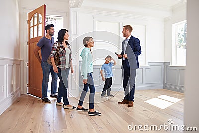 Realtor Showing Hispanic Family Around New Home Stock Photo