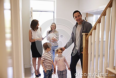 Realtor Showing Young Family Around Property For Sale Stock Photo