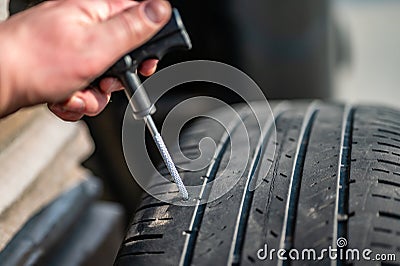 Reaming tool used to scarify and enlarge a tire puncture before inserting a repair plug Stock Photo