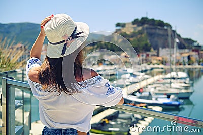 Rear view woman wear hat pose on Denia castle background. Spain Stock Photo