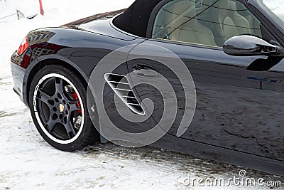Rear fender view of the 2006 sports porsche boxster s coupe roadster prepared for sale with a polished shiny black body on snow Editorial Stock Photo