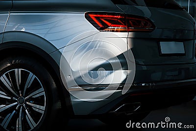 Rear part of brand new modern car. Parked at showroom. Reflection in the headlights Stock Photo