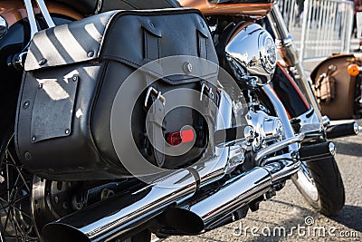 Rear part of the classic motorcycle with saddlebagsm made of black genuine leather and lots of chrome parts. Motorcycle is parked Stock Photo