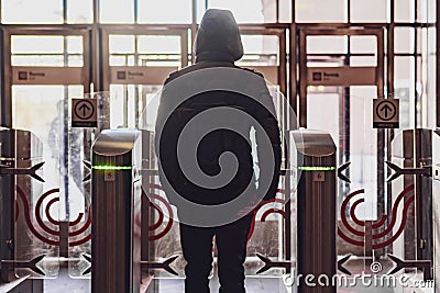 rear portrait of person go through security turnstile b Stock Photo