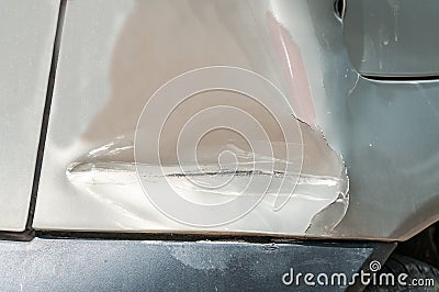 Rear side bumper of broken and damaged car wreck in crash accident with scratched paint in collision close up Stock Photo