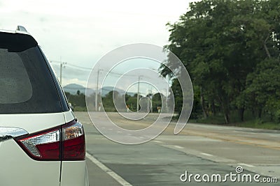 Rear side of white family car driving on the emptry road. Stock Photo