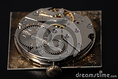 Rear viev of golden old pocket watch with open clockwork lying on black table surface. Mechanism of golden vintage watch Stock Photo