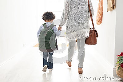 Girl with her mother walking together hand in hand near doorway at home Stock Photo