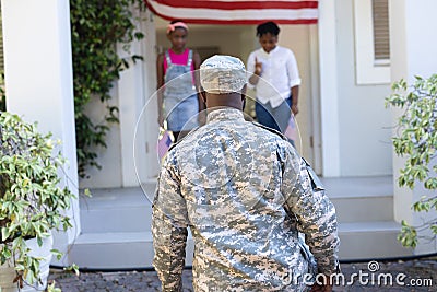 Rear view of african american soldier father greeting son and daughter in front of house Stock Photo