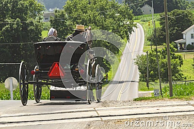 Rear View of an Amish Couple in an Open Horse and Buggy Editorial Stock Photo