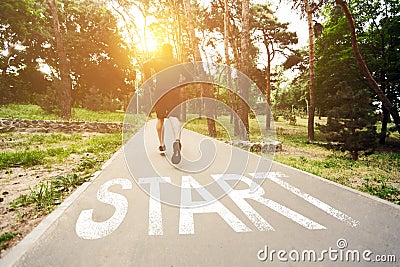 Rear View Of Athlete Passing Start Lettering On Running Path Outdoors Stock Photo