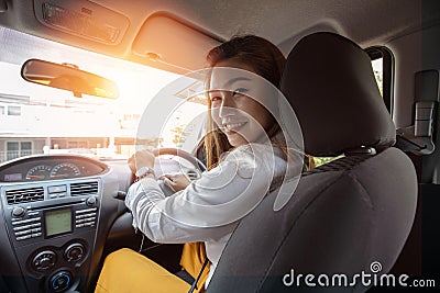 Rear view Beautiful attractive young woman smile in casual sitting in car Stock Photo