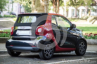 Rear view of black and red smart micro car parked in the street Editorial Stock Photo