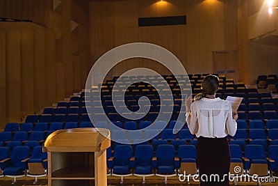 Businesswoman practicing and learning script while standing in the auditorium Stock Photo