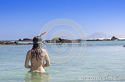 Rear View of brunette woman wearing snorkel and mask looking to Stock Photo