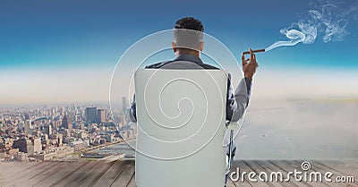 Rear view of businessman sitting on chair and looking at sea while smoking cigar Stock Photo