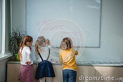 rear view of children writing and drawing robot education signs Stock Photo