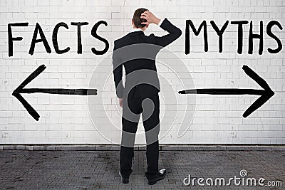 Businessman Looking At Arrow Signs Below Facts And Myths Stock Photo