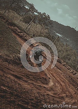 Rear view of a crazy motor cyclist (biker) in dirt riding their off-road motorbike Editorial Stock Photo