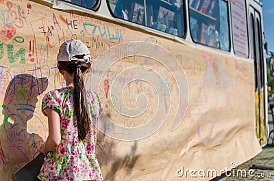 Rear view of cute little girl drawing a picture on the wall Editorial Stock Photo