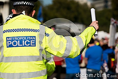 Large Metropolitan Police sign on the high visibility worn by an officer. Editorial Stock Photo