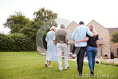 Rear View Of Family With Senior Parents And Adult Offspring Walking And Talking In Garden Together Stock Photo