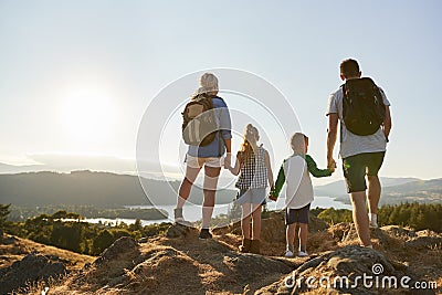 Rear View Of Family Standing At Top Of Hill On Hike Through Countryside In Lake District UK Stock Photo