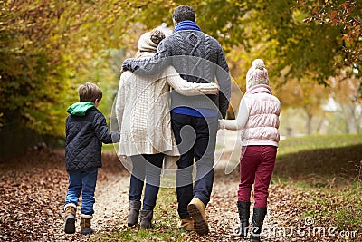 Rear View Of Family Walking Along Autumn Path Stock Photo