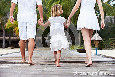 Rear View Of Family Walking On Wooden Jetty Stock Photo