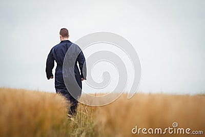 Rear view of farmer walking in the field Stock Photo